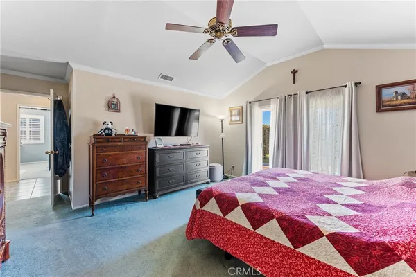 a bedroom with a bed dresser and a flat tv screen