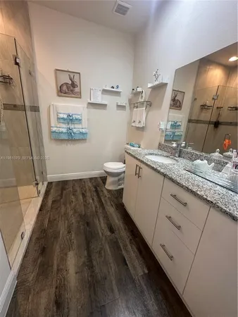 a spacious bathroom with a granite countertop sink toilet and a mirror