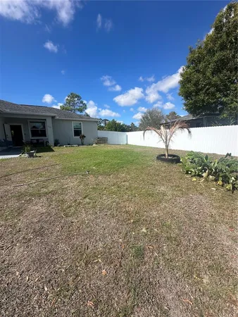 a view of a house with a yard and potted plants