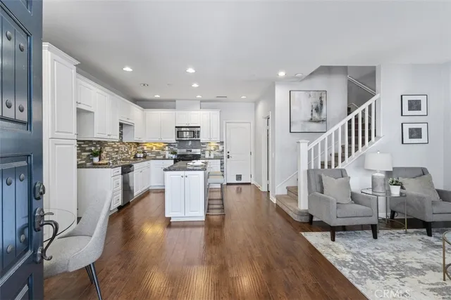 a kitchen with white cabinets and stainless steel appliances