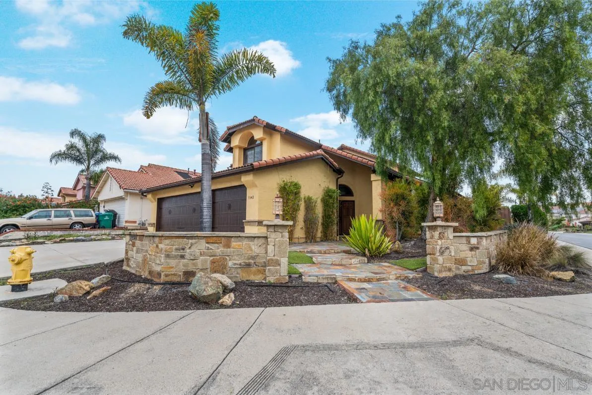 a view of a white house with a large tree