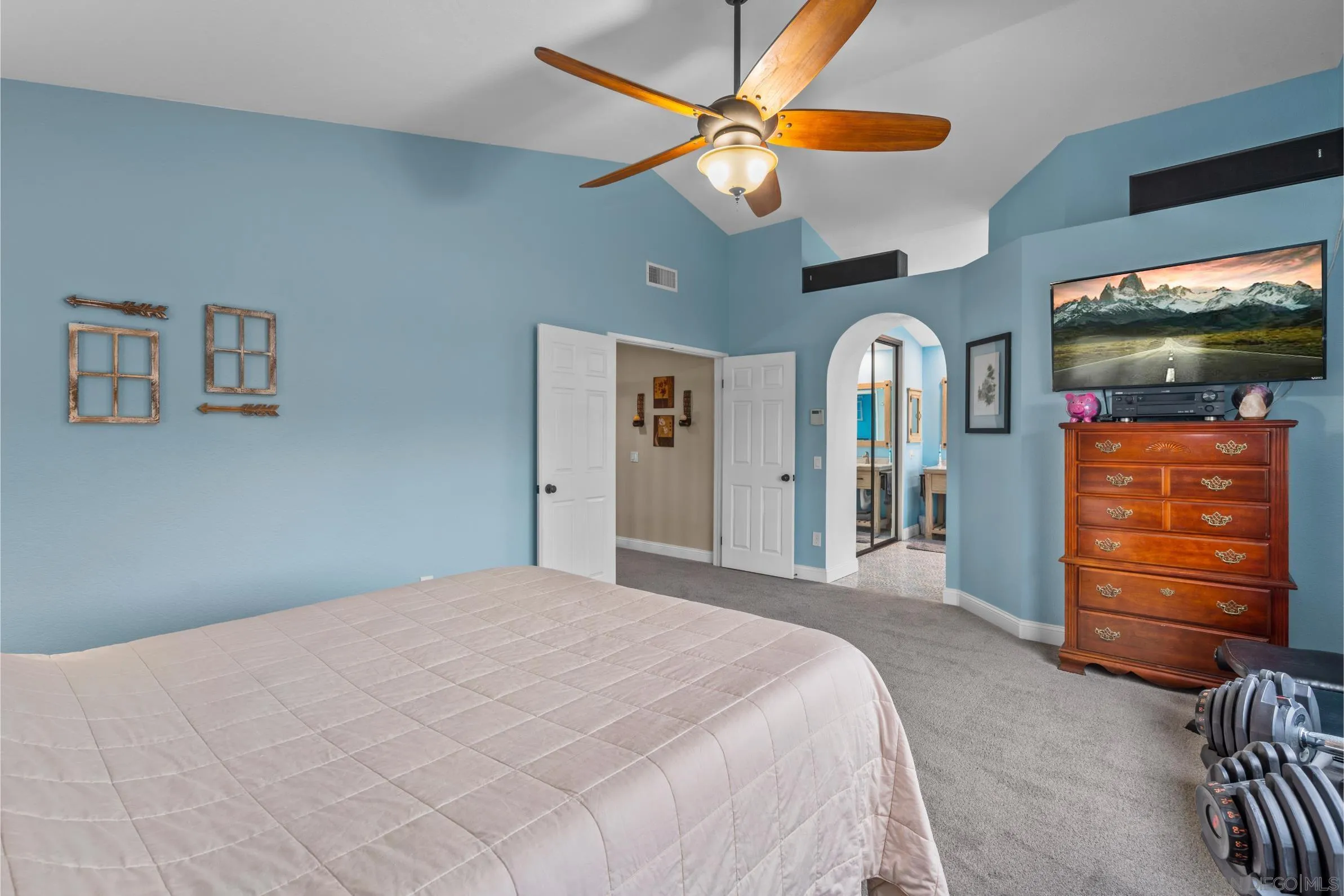 9342 Parus Point San Diego, CA 92129 - Photo 19 of 44 a bedroom with a bed a dresser and a chandelier