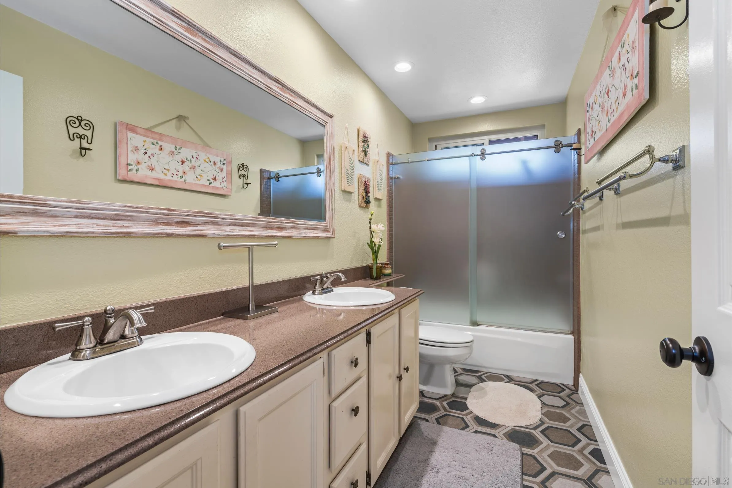 9342 Parus Point San Diego, CA 92129 - Photo 24 of 44 a bathroom with a double vanity sink toilet mirror and shower