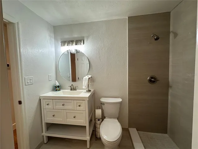 a bathroom with a toilet a sink and mirror