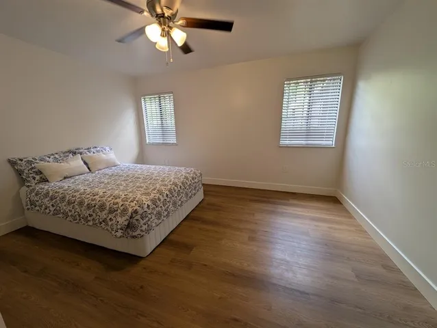 a bedroom with a bed and wooden floor