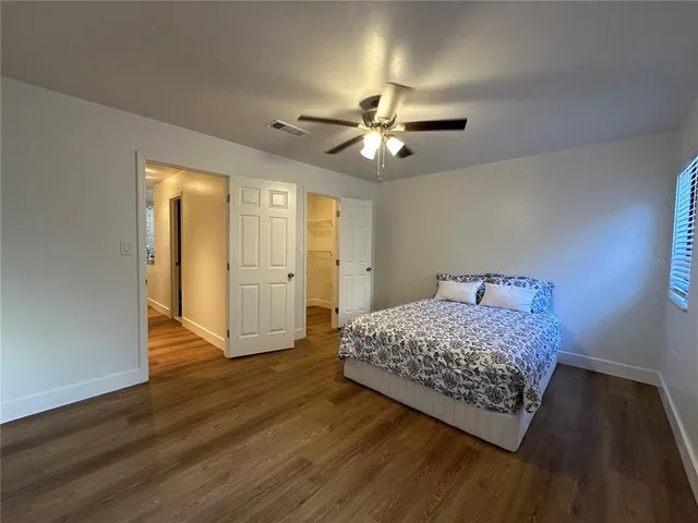 a bedroom with a bed and wooden floor