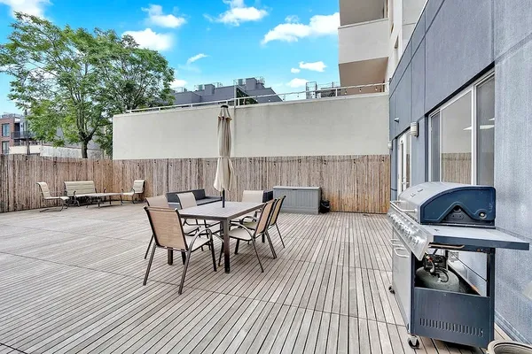 a view of a patio with table and chairs with wooden floor and fence