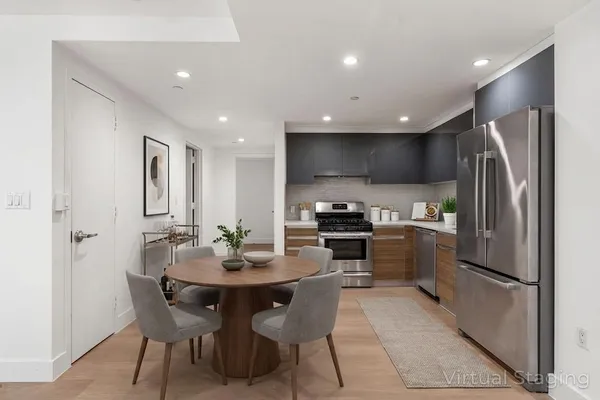 a kitchen with a refrigerator and chairs