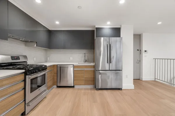 a kitchen with stainless steel appliances granite countertop a refrigerator and a stove