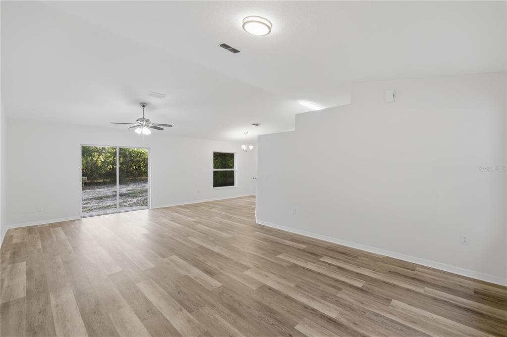 14185 Southwest 28th Lane Ocala, FL 34481 - Photo 2 of 12 an empty room with wooden floor and windows