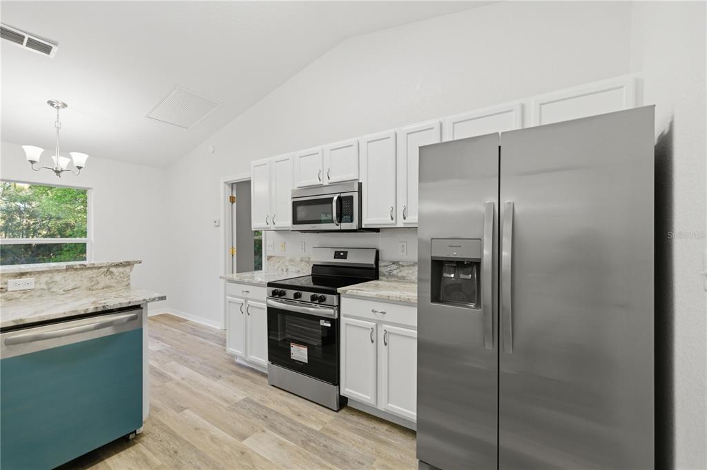 14185 Southwest 28th Lane Ocala, FL 34481 - Photo 5 of 12 a kitchen with a refrigerator stove and microwave