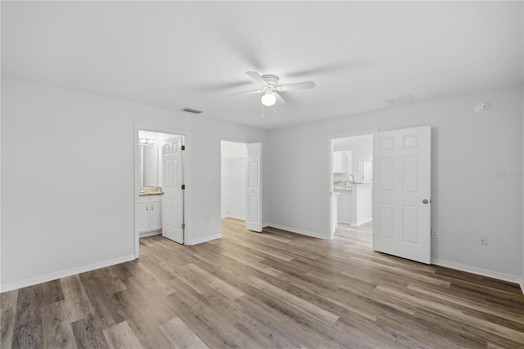 14185 Southwest 28th Lane Ocala, FL 34481 - Photo 6 of 12 an empty room with wooden floor and ceiling fan