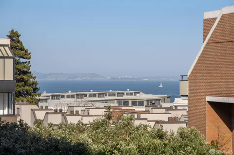 a view of a hallway with closet and wooden floor