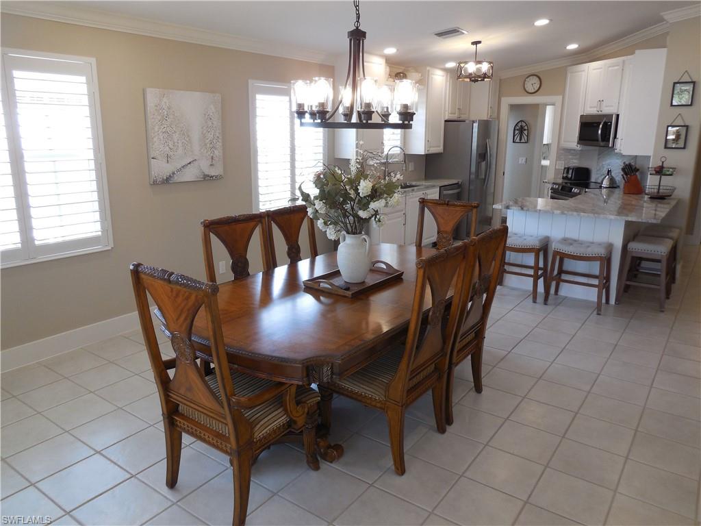 5441 Guadeloupe Way Naples, FL 34119 - Photo 12 of 45 Dining room with a wealth of natural light, crown molding, a chandelier, and visible vents