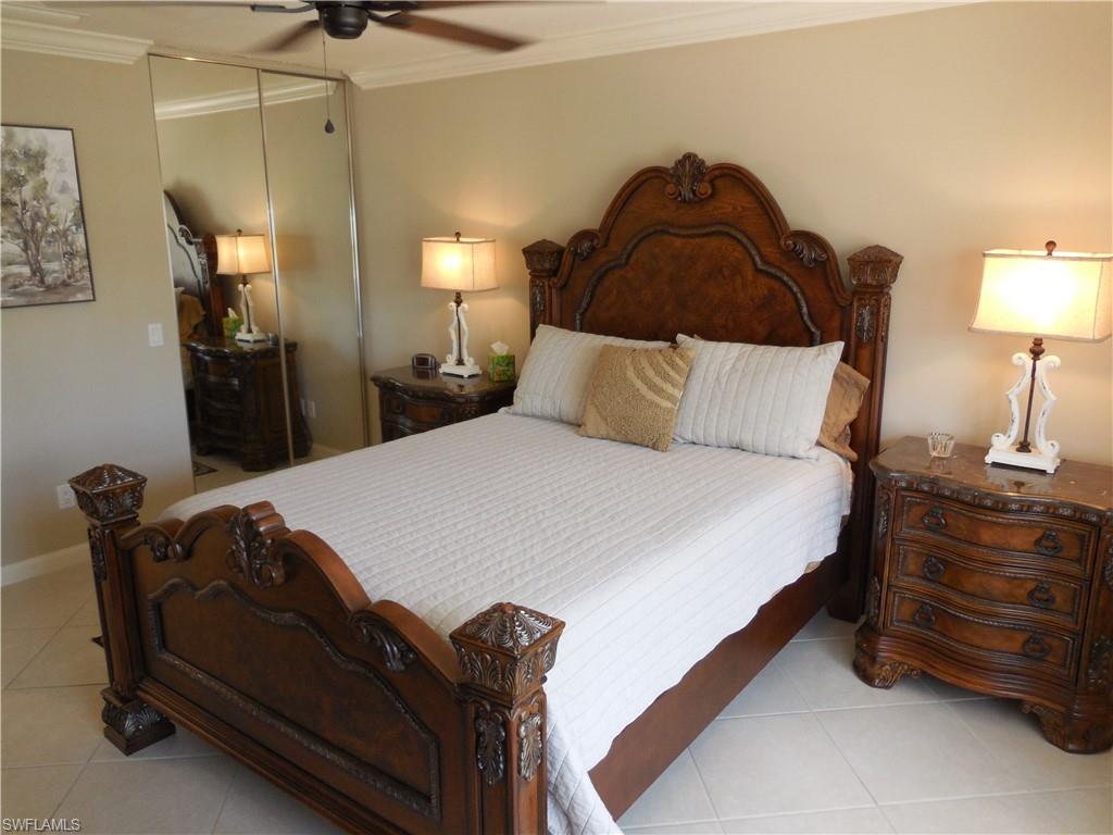 5441 Guadeloupe Way Naples, FL 34119 - Photo 13 of 45 Tiled bedroom with ceiling fan, baseboards, crown molding, and a closet