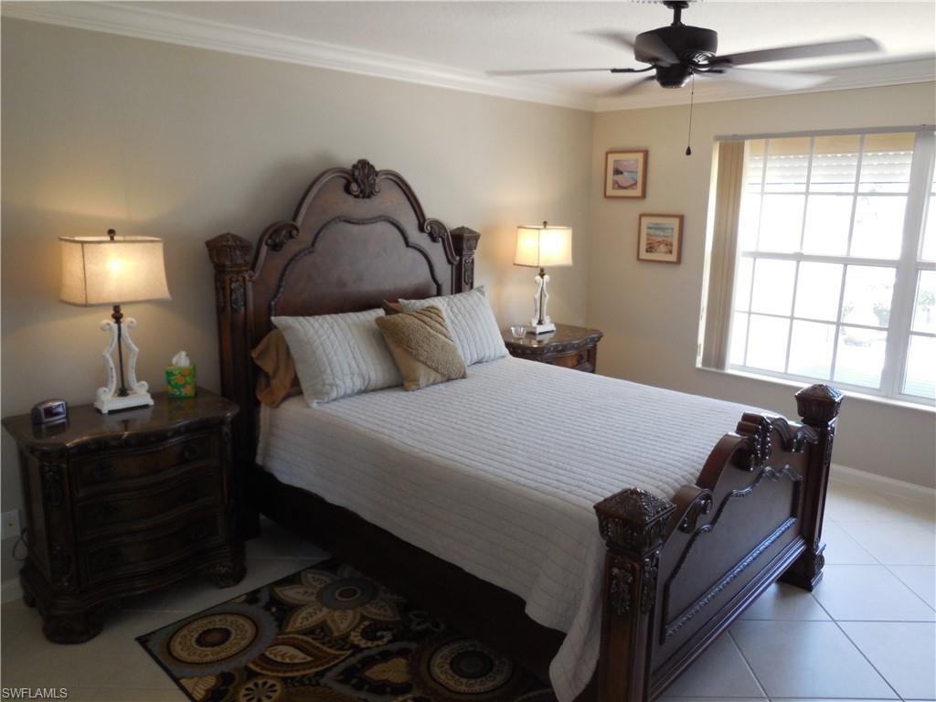 5441 Guadeloupe Way Naples, FL 34119 - Photo 14 of 45 Bedroom featuring a ceiling fan, baseboards, light tile patterned floors, and crown molding
