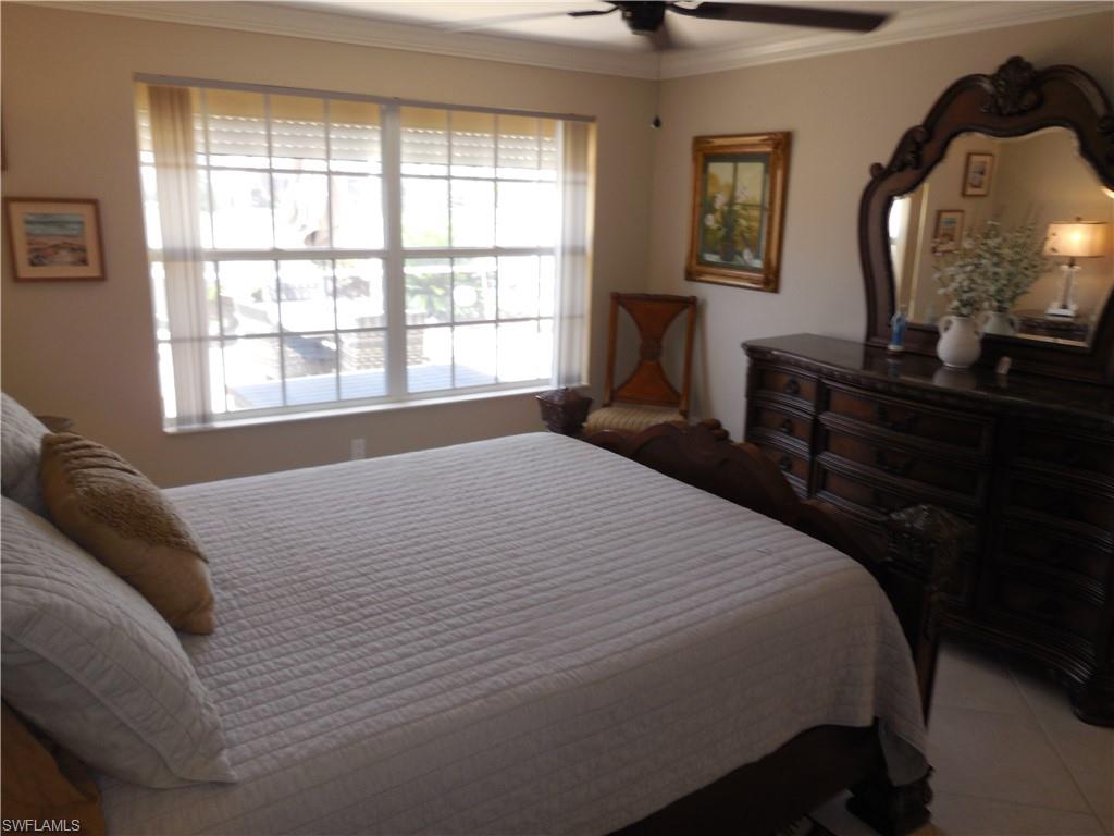 5441 Guadeloupe Way Naples, FL 34119 - Photo 15 of 45 Bedroom featuring ceiling fan, light tile patterned floors, and crown molding