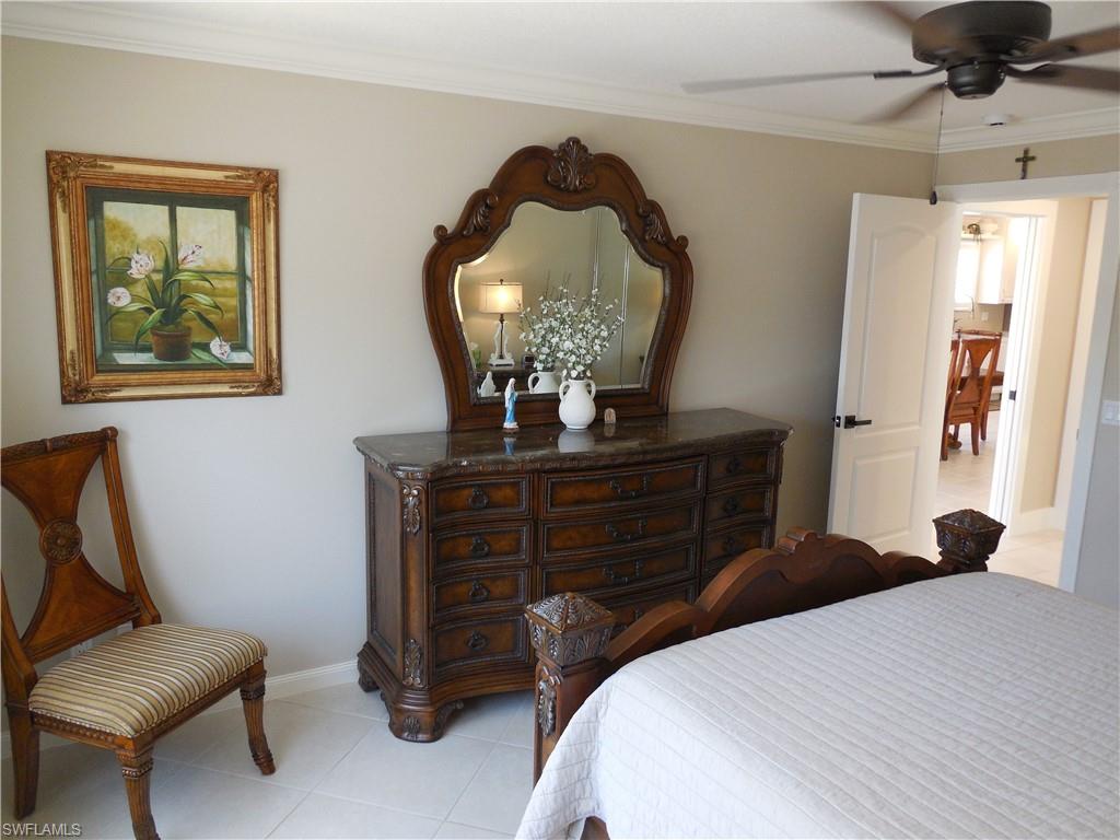 5441 Guadeloupe Way Naples, FL 34119 - Photo 16 of 45 Bedroom featuring ceiling fan, baseboards, ornamental molding, and light tile patterned floors