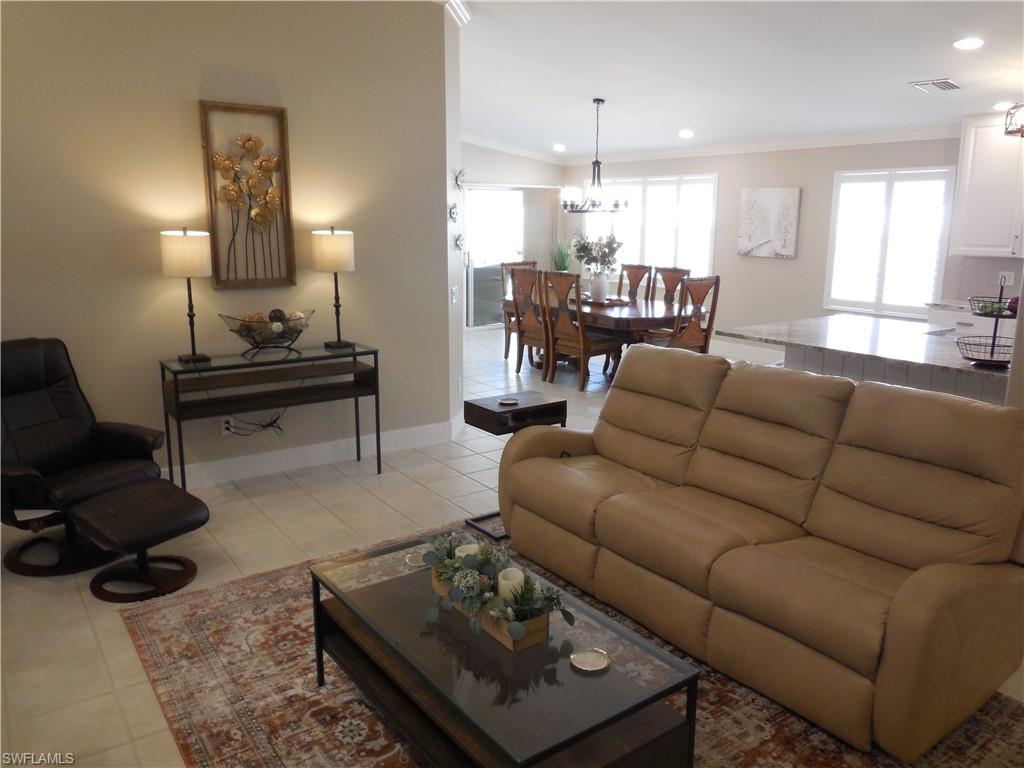 5441 Guadeloupe Way Naples, FL 34119 - Photo 20 of 45 Living room with visible vents, recessed lighting, a notable chandelier, crown molding, and light tile patterned floors