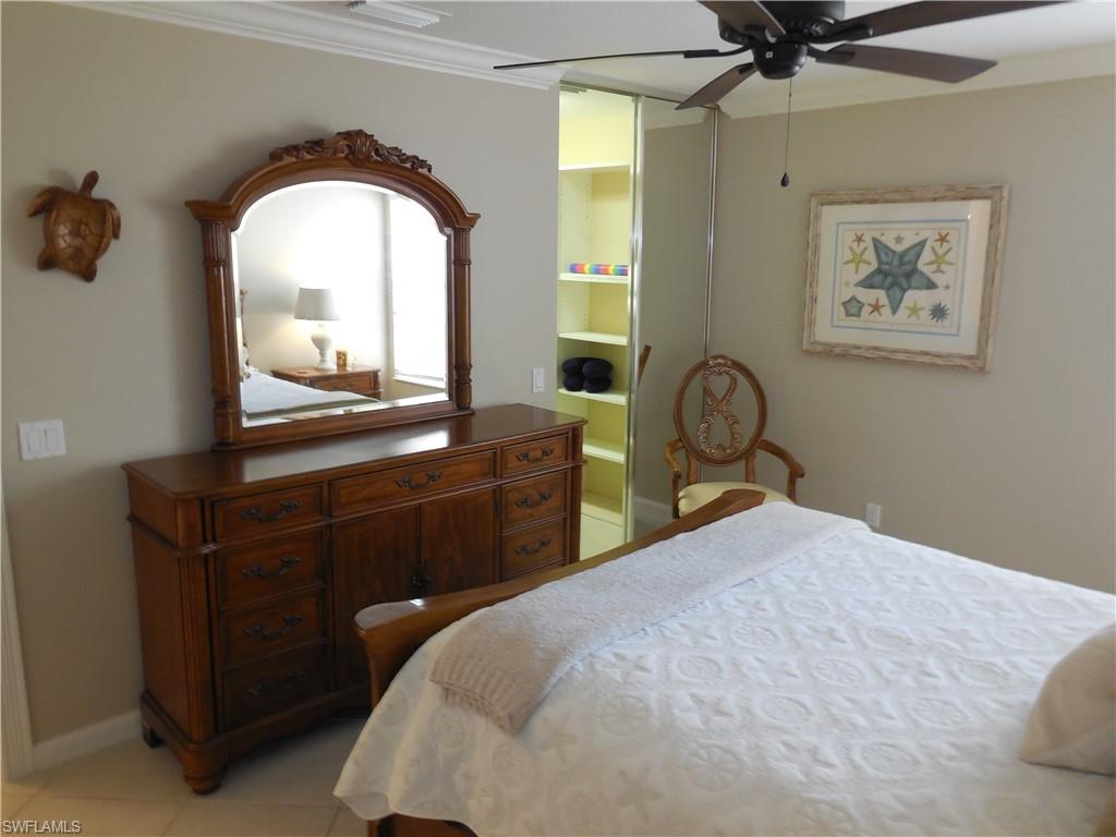 5441 Guadeloupe Way Naples, FL 34119 - Photo 21 of 45 Bedroom featuring light tile patterned floors, ceiling fan, baseboards, ensuite bath, and ornamental molding
