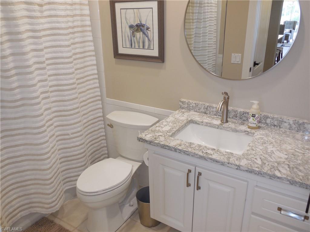 5441 Guadeloupe Way Naples, FL 34119 - Photo 22 of 45 Bathroom with toilet, vanity, and wainscoting