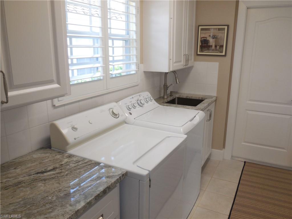 5441 Guadeloupe Way Naples, FL 34119 - Photo 24 of 45 Laundry room with cabinet space, washer and clothes dryer, light tile patterned floors, and a sink