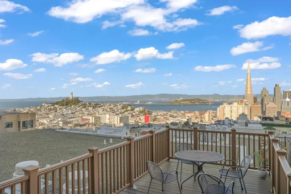 a view of roof deck with two chairs and wooden fence