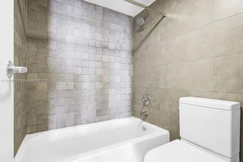 a white bath tub sitting next to a white toilet