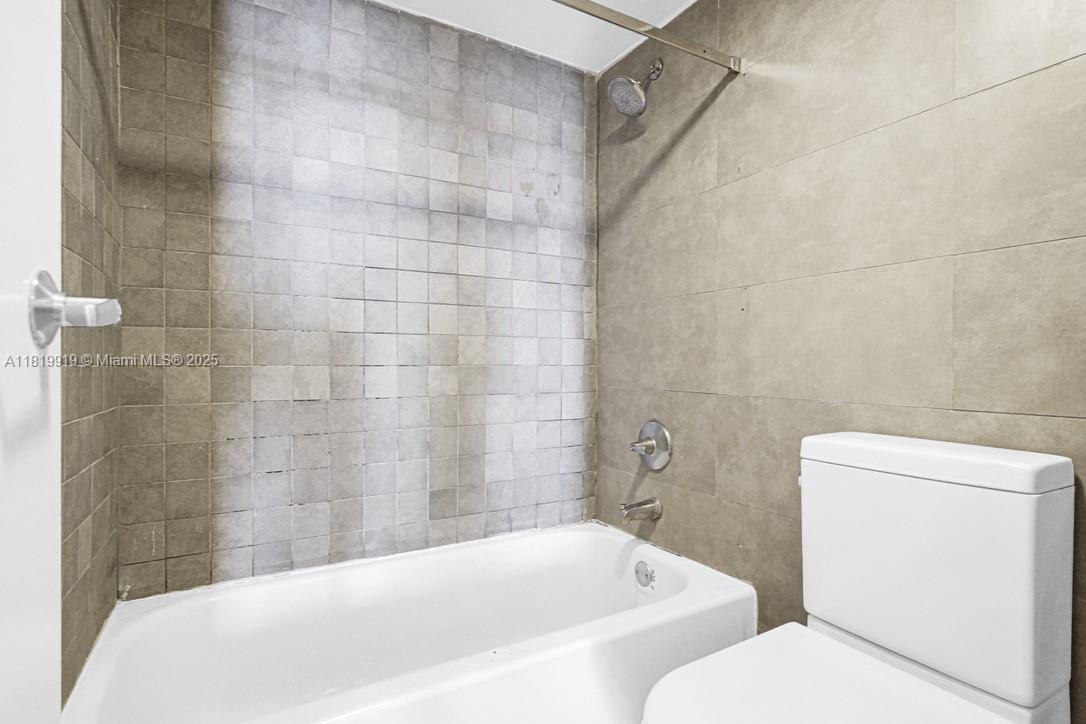 100 Bayview Drive, Unit 1223 Sunny Isles Beach, FL 33160 - Photo 19 of 34 a white bath tub sitting next to a white toilet