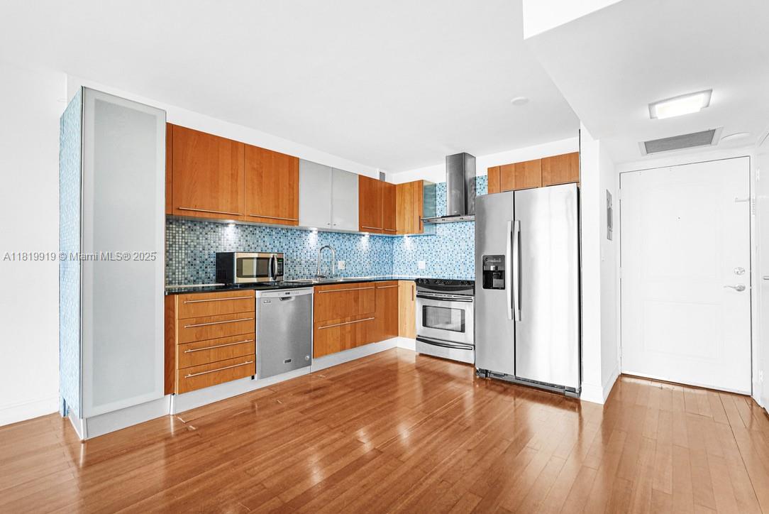 100 Bayview Drive, Unit 1223 Sunny Isles Beach, FL 33160 - Photo 9 of 34 a kitchen with stainless steel appliances granite countertop a refrigerator a sink dishwasher a stove with wooden cabinets