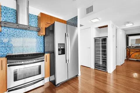 a kitchen with wooden floors and stainless steel appliances