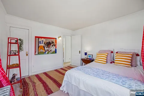a bedroom with bed and wooden floor