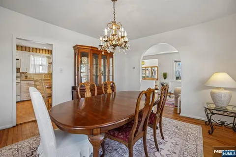 a dining room with furniture a chandelier and wooden floor