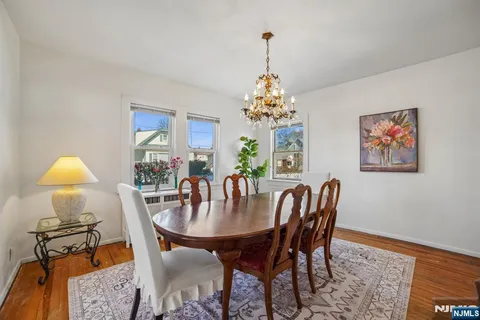 a dining room with furniture a chandelier and wooden floor