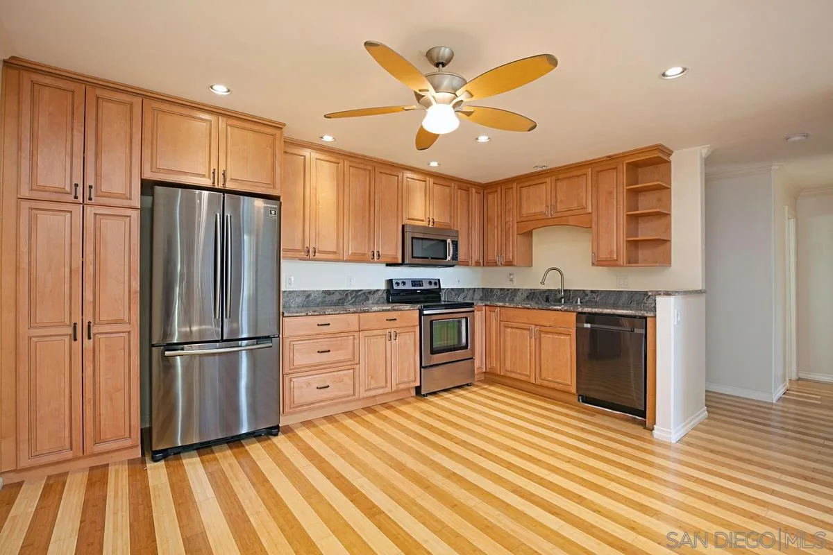 2510 Torrey Pines Road, Unit 408 La Jolla, CA 92037 - Photo 15 of 15 a kitchen with granite countertop stainless steel appliances and wooden cabinets