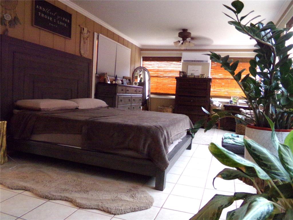 33068 Round Table Road Dade City, FL 33523 - Photo 61 of 82 a bedroom with a bed lamp and a potted plant