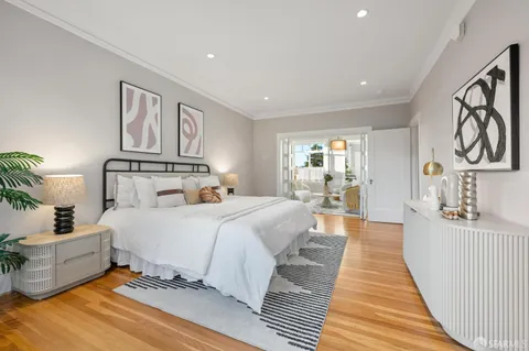 a bedroom with a large bed and a wooden floor