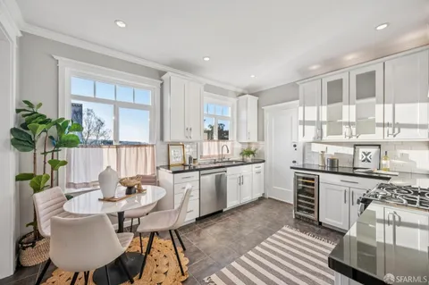 a kitchen with stainless steel appliances kitchen island granite countertop a stove and white cabinets