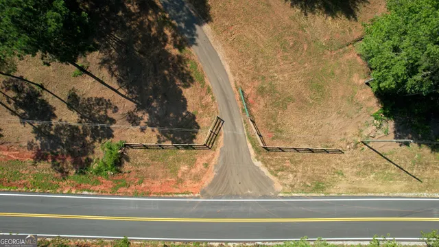 an aerial view of residential house with outdoor space and trees all around