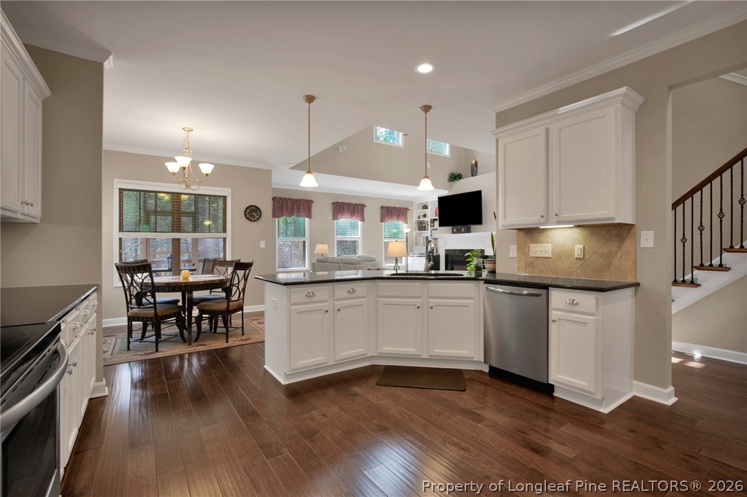 207 Pinetop Drive Carthage, NC 28327 - Photo 17 of 50 a kitchen with stainless steel appliances granite countertop a stove top oven a sink dishwasher a dining table and chairs with wooden floor