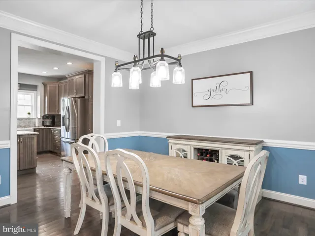 a view of a dining room and livingroom with furniture wooden floor a chandelier