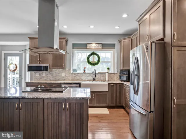 a kitchen with stainless steel appliances granite countertop a sink stove and cabinets