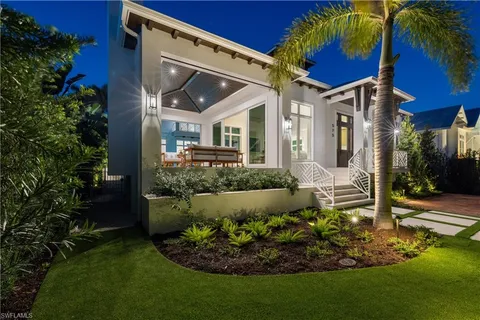 a view of a house with a small yard and potted plants