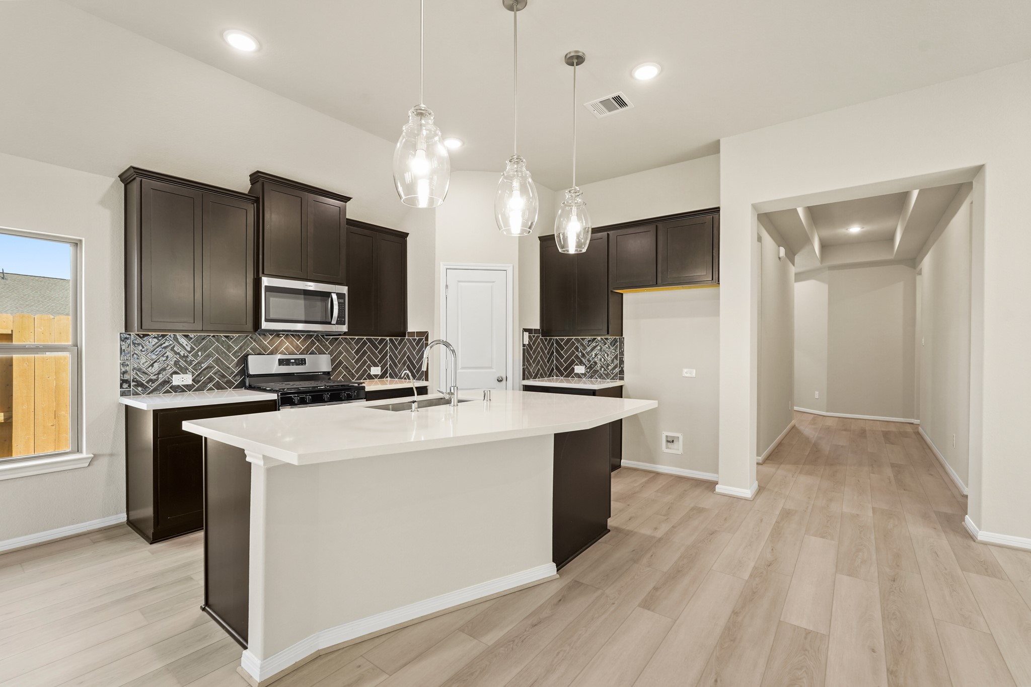 26530 Jolly Prairie Drive Hockley, TX 77447 - Photo 4 of 36 a kitchen with kitchen island a sink stainless steel appliances and cabinets