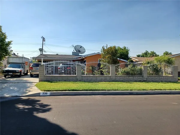 a view of a house with a yard and potted plants