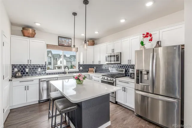 a kitchen with a sink stainless steel appliances and white cabinets