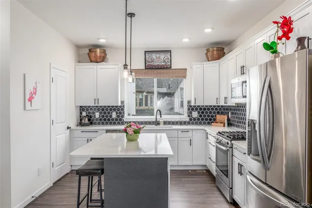 a kitchen with a sink stainless steel appliances and white cabinets