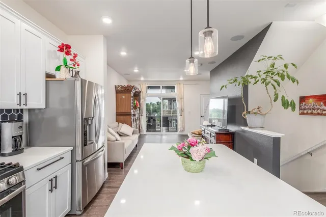 a kitchen with granite countertop a refrigerator and chandelier
