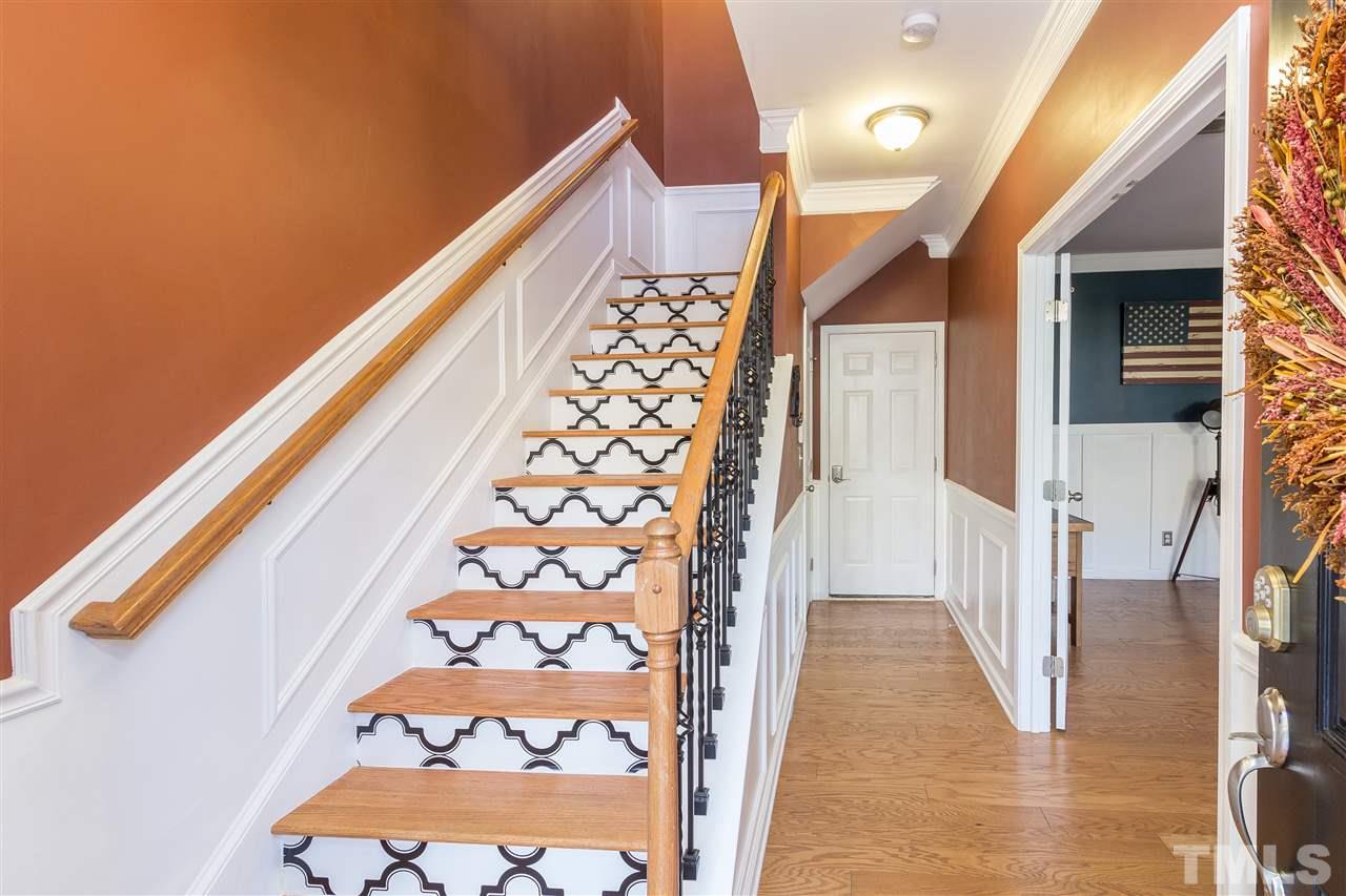 9135 Falkwood Road Raleigh, NC 27617 - Photo 3 of 25 Your guests will be greeted in style! The front entry has upgraded hardwood treads, iron spindles and custom risers on stairs, along with wainscoting throughout. The door at the back is to the garage and there is also a coat closet.