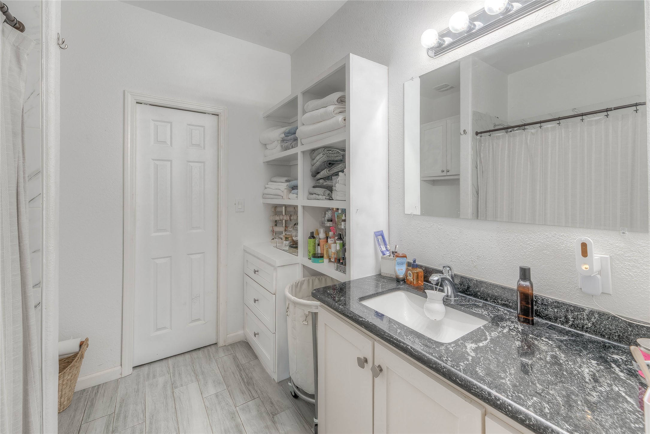 627 Pinewood Drive Trinity, TX 75862 - Photo 11 of 36 a bathroom with a granite countertop sink a mirror and shower